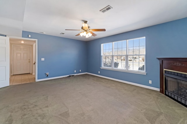 unfurnished living room with baseboards, visible vents, a fireplace, and carpet flooring