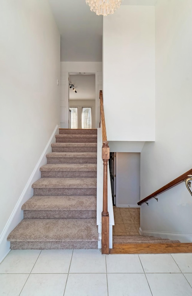 staircase featuring tile patterned flooring and baseboards