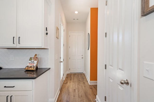 hallway with light wood-style floors, recessed lighting, visible vents, and baseboards