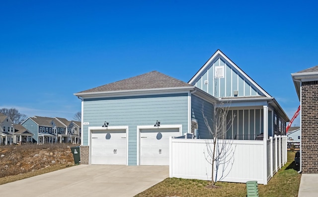 view of front of home featuring driveway, a shingled roof, fence, and brick siding