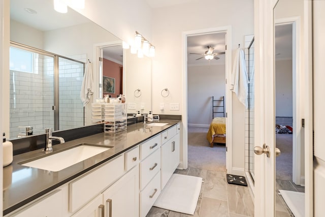 bathroom featuring double vanity, a ceiling fan, a stall shower, connected bathroom, and a sink