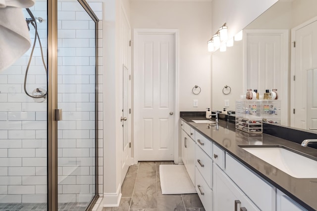 bathroom with marble finish floor, a sink, a shower stall, and double vanity