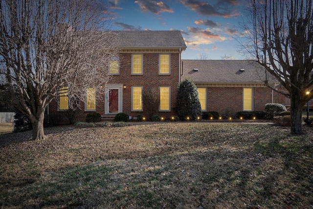 colonial house featuring brick siding