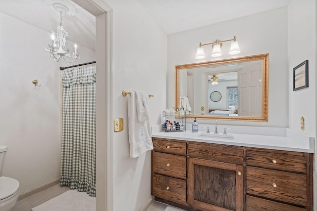 ensuite bathroom with baseboards, ensuite bath, vanity, and toilet