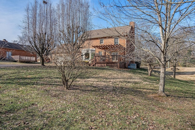 exterior space featuring a chimney, a front yard, a wooden deck, and a pergola