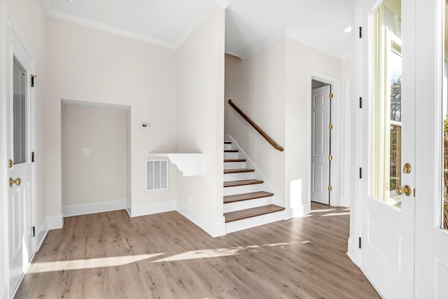 foyer featuring stairway, wood finished floors, visible vents, and crown molding