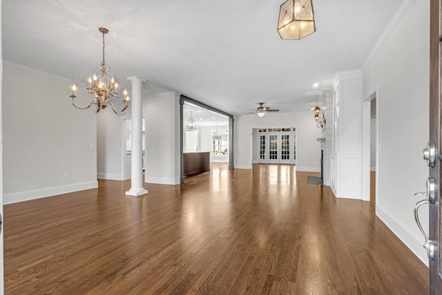 unfurnished living room featuring ornate columns, ornamental molding, dark wood-type flooring, and ceiling fan with notable chandelier