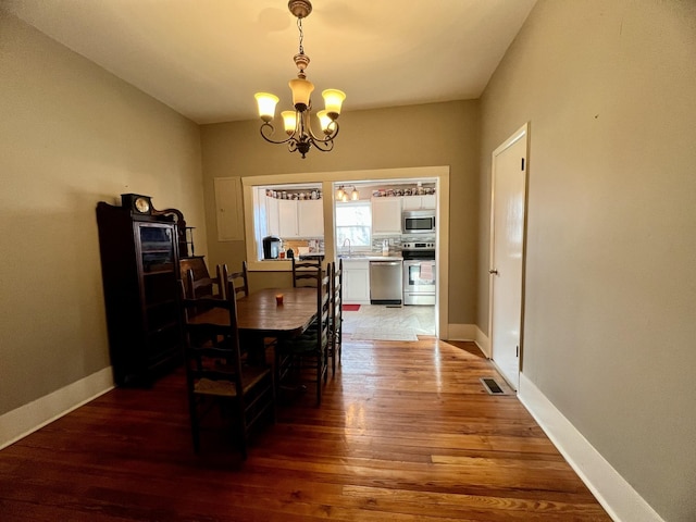 dining area with light wood-style floors, visible vents, baseboards, and a notable chandelier