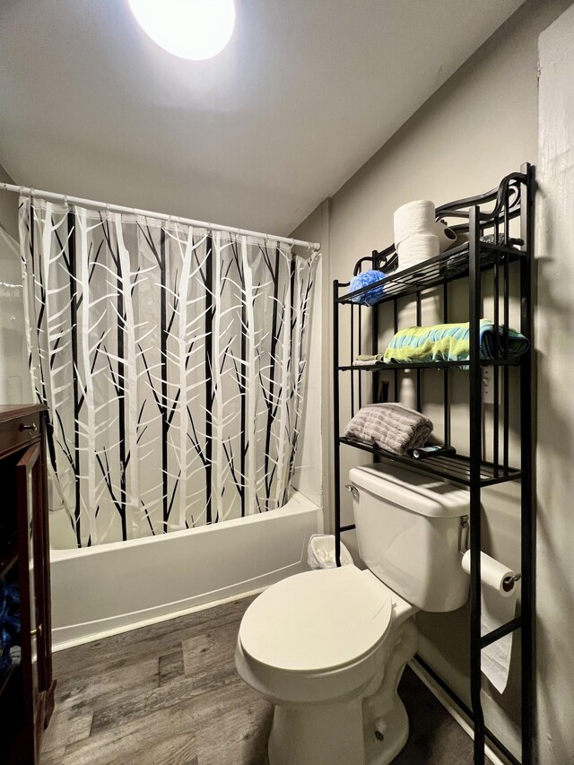 full bathroom with toilet, vaulted ceiling, wood finished floors, and shower / tub combo with curtain