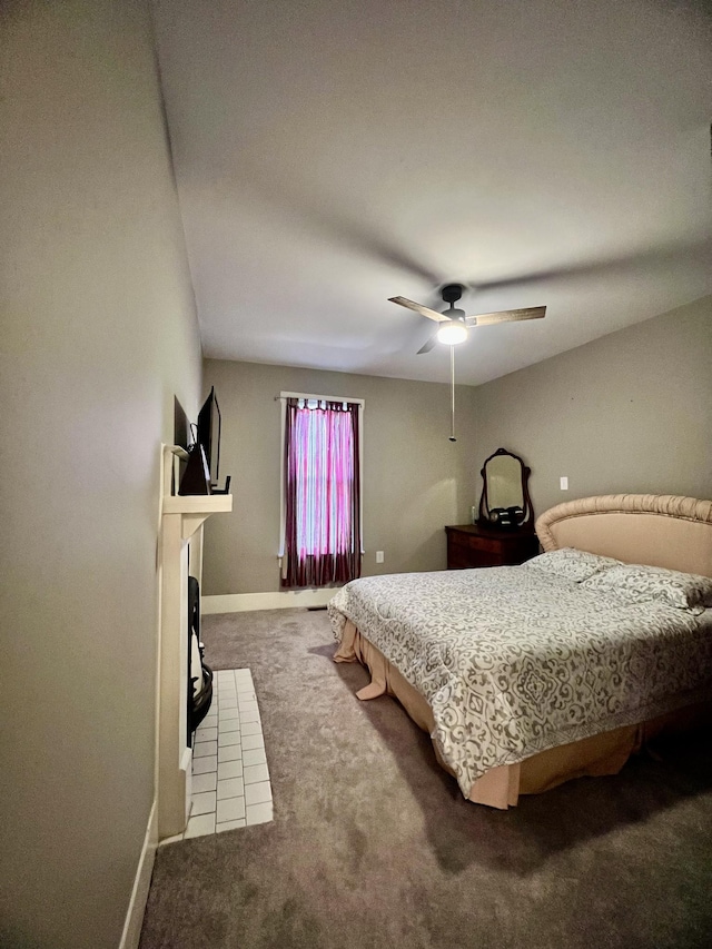 bedroom with carpet floors, a fireplace, baseboards, and a ceiling fan