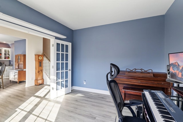 home office with baseboards and light wood finished floors