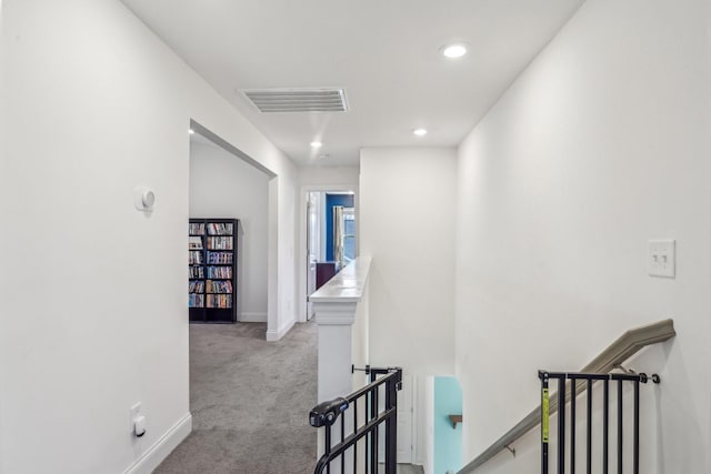 corridor with carpet floors, recessed lighting, visible vents, an upstairs landing, and baseboards