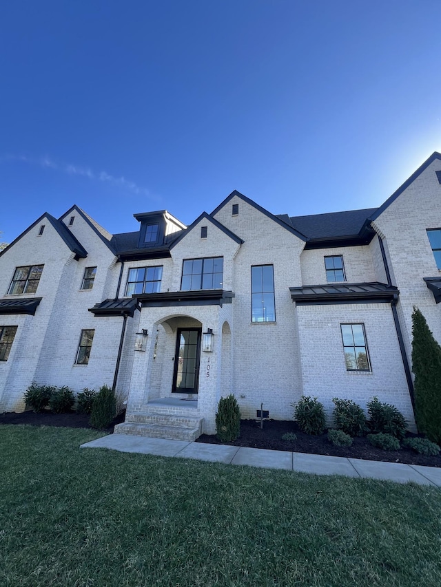 view of front of house featuring a front lawn and brick siding