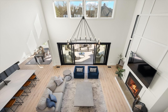 105 Stillwind Ct, Nolensville, TN 37135 - living room with a warm lit fireplace, plenty of natural light, a chandelier, and wood finished floors