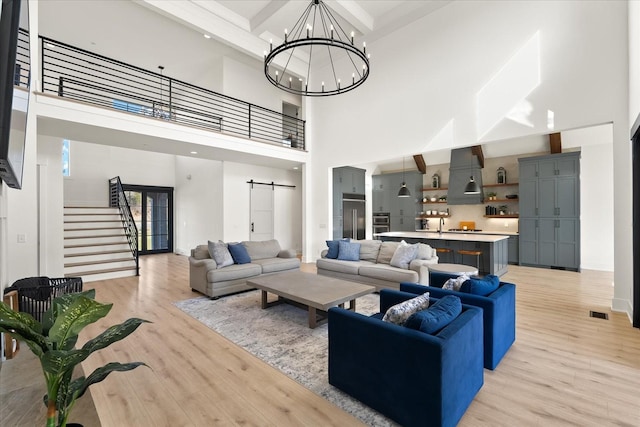 105 Stillwind Ct, Nolensville, TN 37135 - living area with stairway, light wood-style floors, a barn door, and a towering ceiling