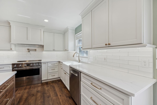 kitchen with white cabinets, decorative backsplash, dark wood-type flooring, stainless steel appliances, and a sink