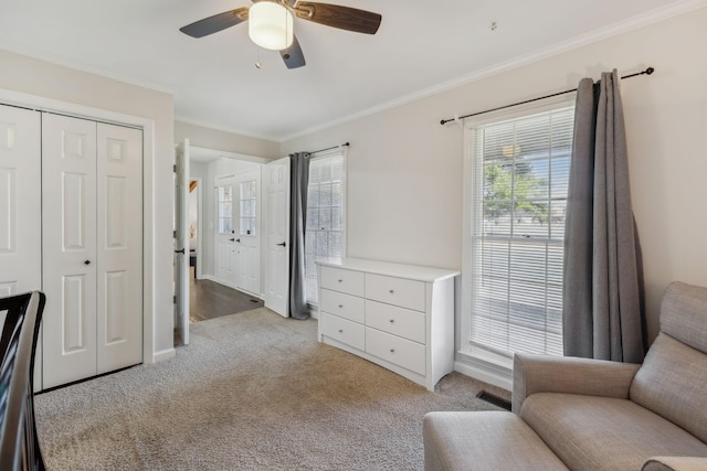 sitting room featuring visible vents, ornamental molding, a ceiling fan, and light colored carpet