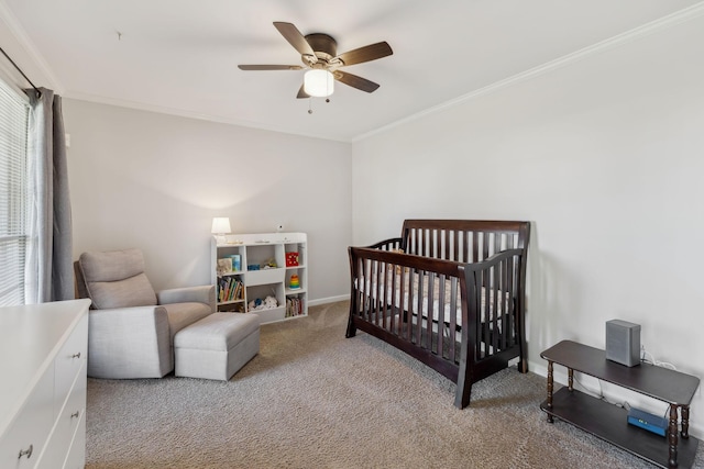 bedroom featuring baseboards, ceiling fan, crown molding, carpet floors, and a nursery area