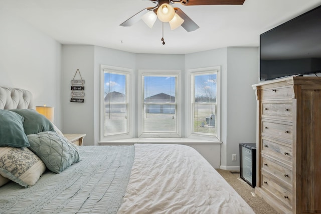 bedroom featuring baseboards, a ceiling fan, and light colored carpet