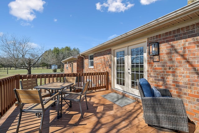 deck with french doors and outdoor dining area