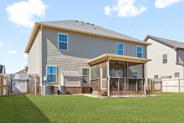 rear view of property with central AC, a lawn, a gate, and a sunroom