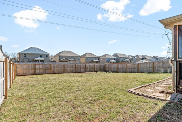 view of yard featuring a fenced backyard and a residential view