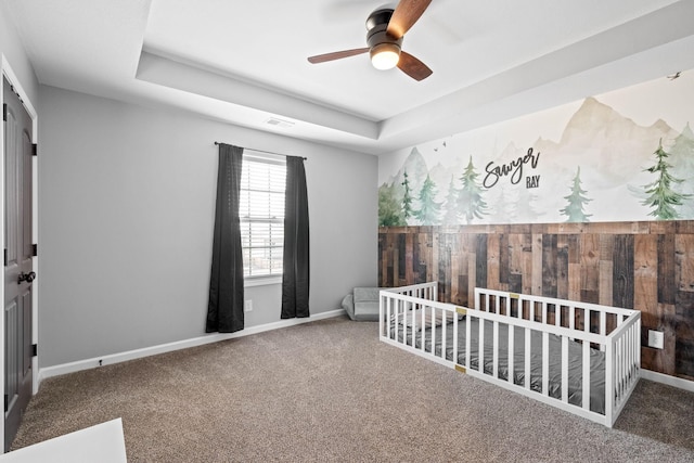 bedroom with carpet floors, visible vents, baseboards, and a raised ceiling