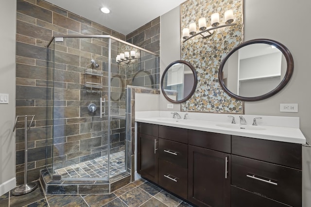 full bath featuring double vanity, a shower stall, and a sink