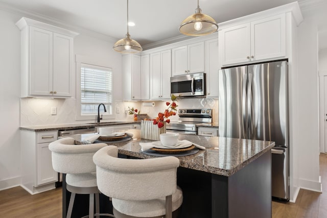 kitchen featuring a sink, white cabinetry, appliances with stainless steel finishes, dark wood-style floors, and crown molding