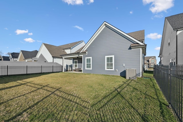 back of property with a fenced backyard and a lawn