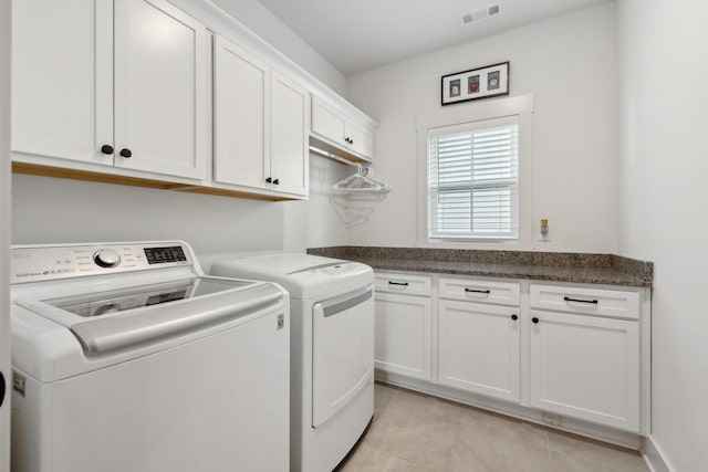 laundry room featuring cabinet space, washing machine and dryer, visible vents, and light tile patterned flooring