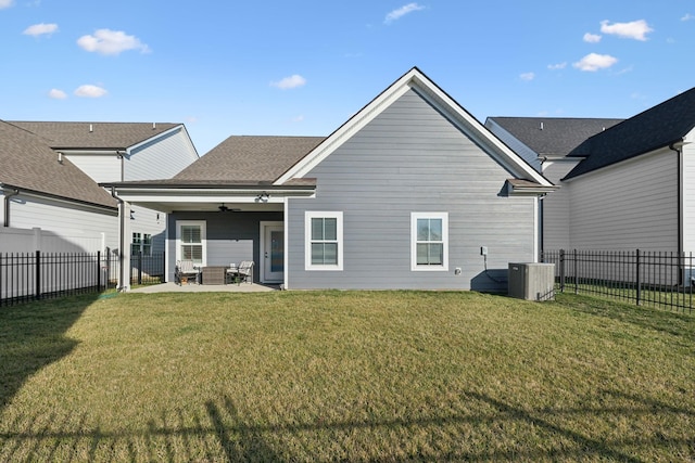 rear view of property with a yard, central AC, ceiling fan, and a fenced backyard