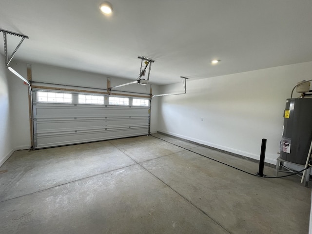 garage featuring water heater, a garage door opener, and baseboards