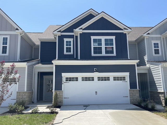 craftsman-style house featuring board and batten siding, stone siding, driveway, and a garage