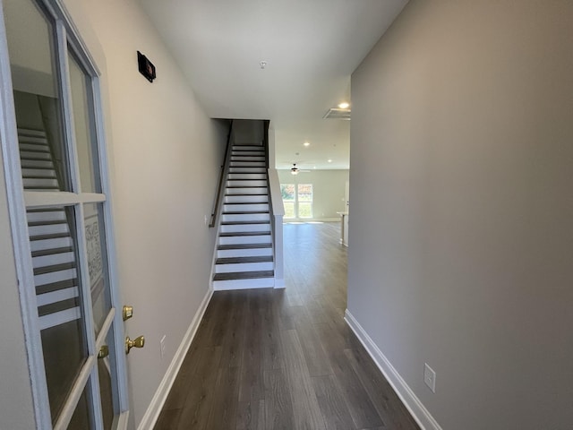 corridor with recessed lighting, dark wood finished floors, baseboards, and stairs