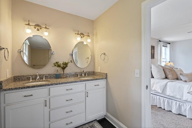 full bath with double vanity, a sink, baseboards, and ensuite bathroom