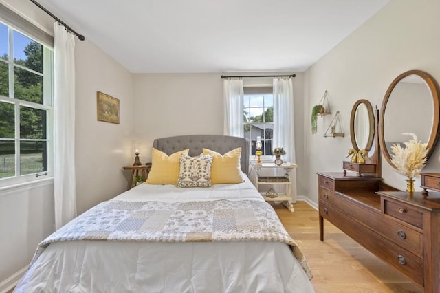 bedroom featuring light wood finished floors and baseboards