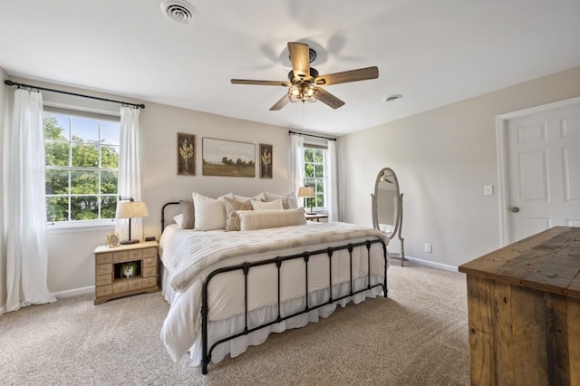 bedroom featuring light colored carpet, visible vents, baseboards, and multiple windows