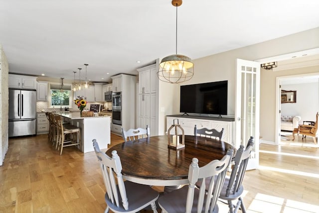 dining area featuring a chandelier, recessed lighting, and light wood-style floors