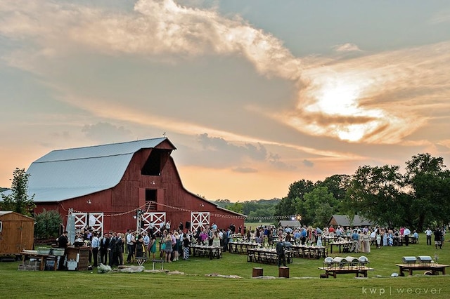 view of home's community with a yard, an outdoor structure, and a barn