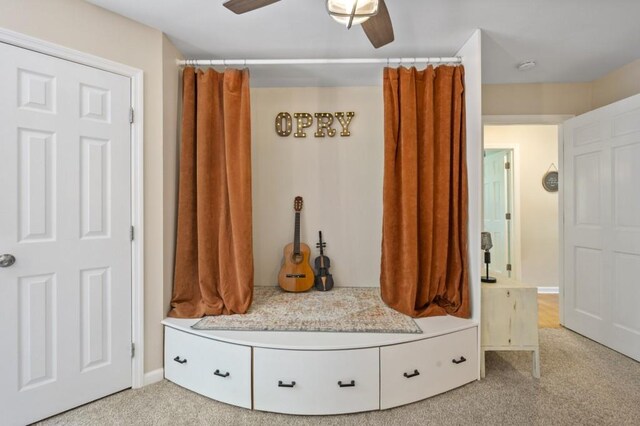 mudroom featuring a ceiling fan, light colored carpet, and baseboards