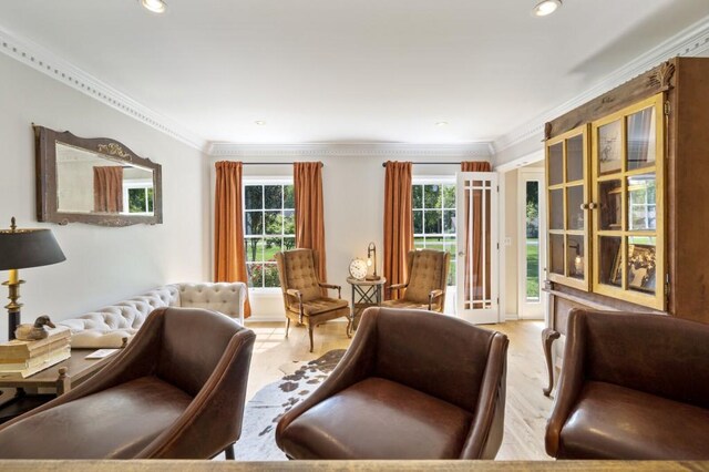 sitting room with crown molding, plenty of natural light, and wood finished floors