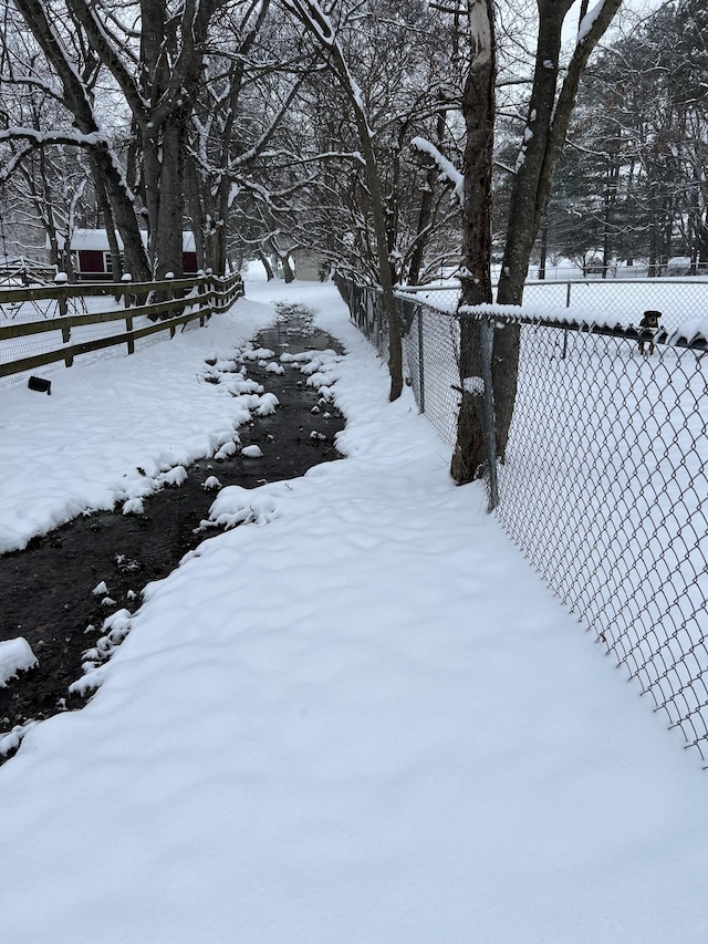 yard layered in snow featuring fence