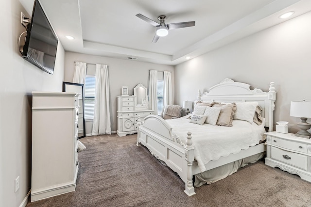 carpeted bedroom featuring visible vents, a tray ceiling, a ceiling fan, and recessed lighting