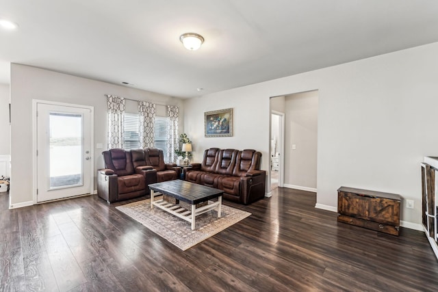 living area with wood finished floors, visible vents, and baseboards