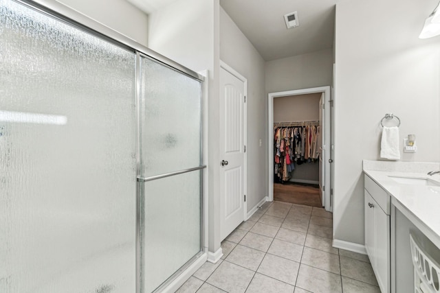 bathroom featuring visible vents, tile patterned floors, a spacious closet, vanity, and a shower stall