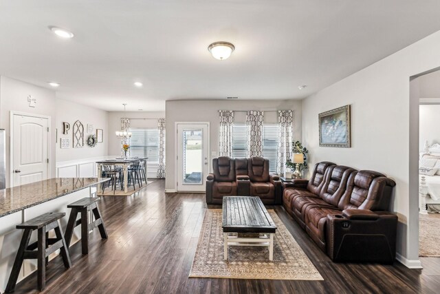 living area with a notable chandelier, dark wood-type flooring, and recessed lighting