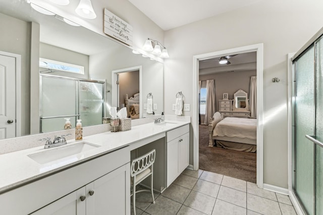 ensuite bathroom with connected bathroom, a shower stall, a sink, and tile patterned floors