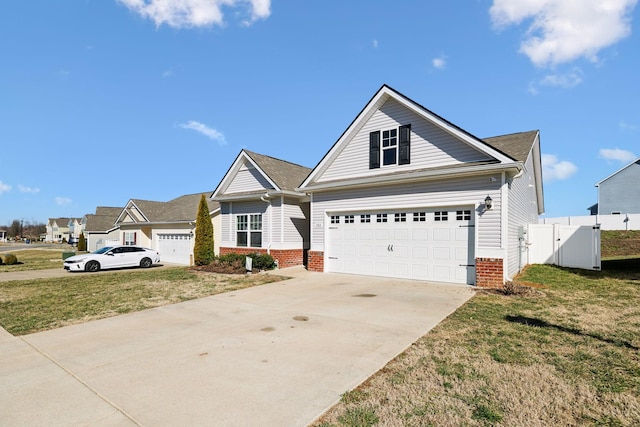 view of front of house with a gate, a front lawn, concrete driveway, and brick siding