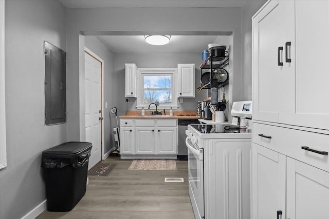 kitchen with light wood finished floors, white range with electric cooktop, electric panel, and white cabinetry